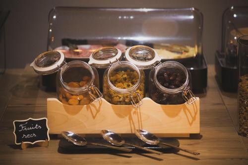 un groupe de cuillères et pots de nourriture sur une table dans l'établissement HOTEL DES NEIGES, à Les Deux Alpes