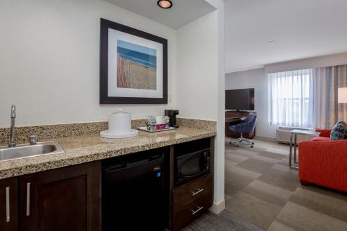 a kitchen with a sink and a living room at Hampton Inn & Suites San Diego-Poway in Poway