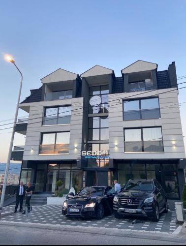 two cars parked in a parking lot in front of a building at Skopje Kale Luxury Apartment in Skopje