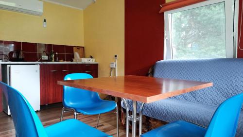 a kitchen with a wooden table and blue chairs at Willipu peremajad in Pusi