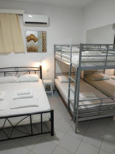 Una habitación con tres literas. en Super economy studio short distance from the beach, en Agia Pelagia