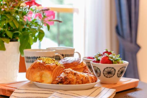 a table with a plate of pastries and a bowl of fruit at B&B Il Viaggio Bologna in Bologna