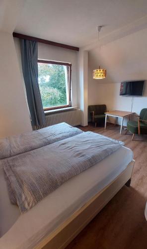 - une chambre avec un grand lit et une fenêtre dans l'établissement Ruhige, grüne Oase in Scharbeutz, 200m vom Strand entfernt, à Scharbeutz