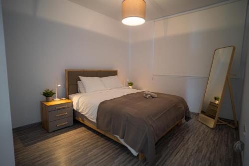 Schlafzimmer mit einem Bett, einer Kommode und einem Spiegel in der Unterkunft Seaview Pearl Suite Larnaca in Larnaka