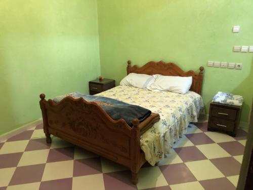 ein Schlafzimmer mit einem Holzbett und zwei Nachttischen in der Unterkunft Appartement Meublé à Louer 95m2 in Tiznit