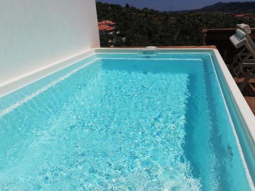 a swimming pool with blue water in front of a building at 2br Suite White gea with private pool no01 in Vassilias