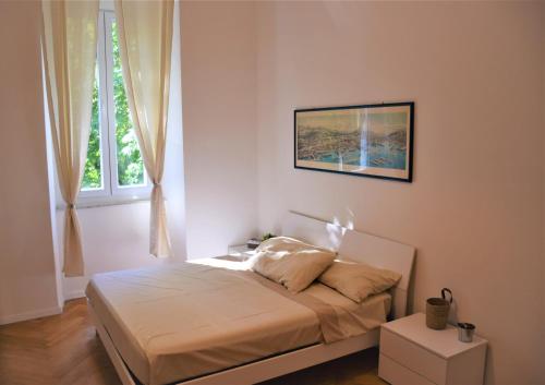 Casa Vacanze Trieste Piace في ترييستي: غرفة نوم بسرير مع صورة على الحائط