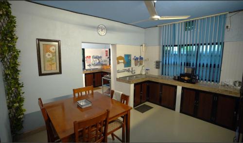 a kitchen and dining room with a table and chairs at UDUPI HOMESTAY Garden Villa in Udupi
