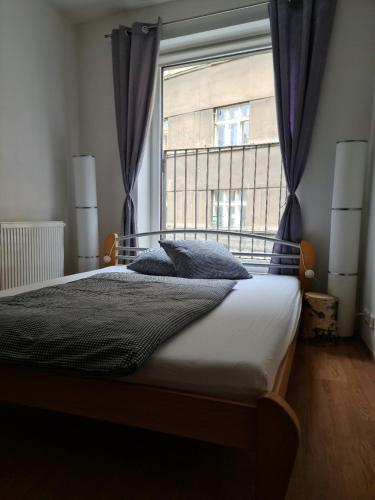a bedroom with a bed and a large window at City Centre Apartments in Liberec