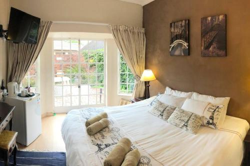 Aqua View Riverside Guesthouse في بارايس: غرفة نوم بها سرير أبيض كبير مع نافذة