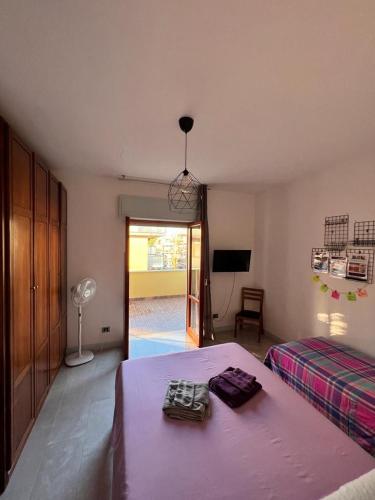 a bedroom with a bed with purple sheets and a fan at Casa Elena in Torvaianica