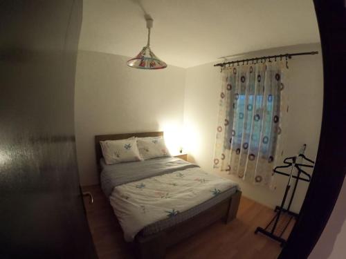 Schlafzimmer mit einem Bett mit einer Lampe und einem Fenster in der Unterkunft Povetarac in Divčibare