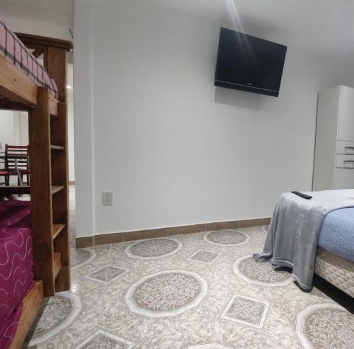 - une chambre avec un lit et une télévision murale à écran plat dans l'établissement Departamento Yekamush 2 Ushuaia, à Ushuaia