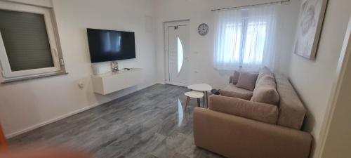a living room with a couch and a flat screen tv at House Vallis Aurea in Povile