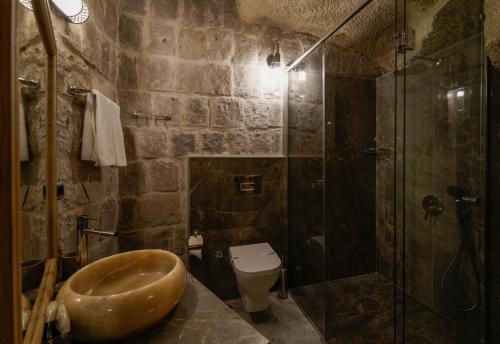 a bathroom with a sink and a shower and a toilet at The Niche Cave Hotel in Goreme