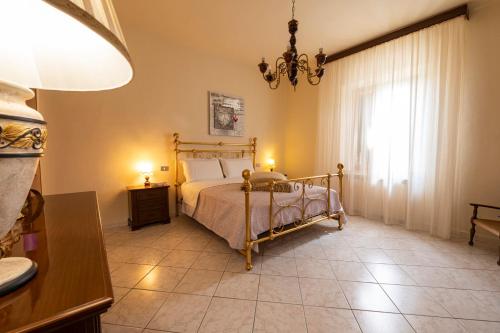 a bedroom with a bed and a chandelier at Casa vacanze Santa Maria in Certaldo