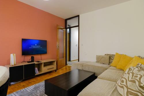 a living room with a couch and a flat screen tv at BLOK apartment in Visoko