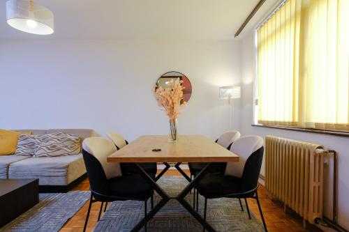 a living room with a table with chairs and a couch at BLOK apartment in Visoko