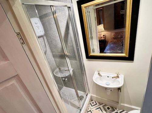 a bathroom with a shower and a sink at Tan-yr-Ogo Gate Lodge, Gwrych Castle in Llanddulas