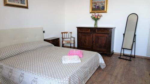 a bedroom with a bed with pink items on it at Borgo 63 Medieval House in Montecelio