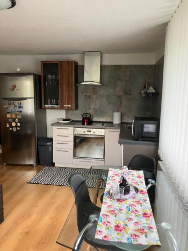 a kitchen with a table with chairs and a refrigerator at Apartmán Karin in Huty
