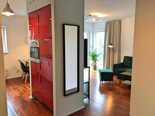 een woonkamer met rode kasten en een spiegel bij Katowice, Johna Baildona, City Center in Katowice