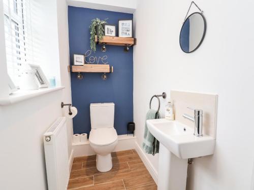 Łazienka z białą toaletą i umywalką w obiekcie 6 Cwrt Griffiths w mieście Rhyl