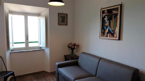 a living room with a couch and a window at Borgo 63 Medieval House in Montecelio