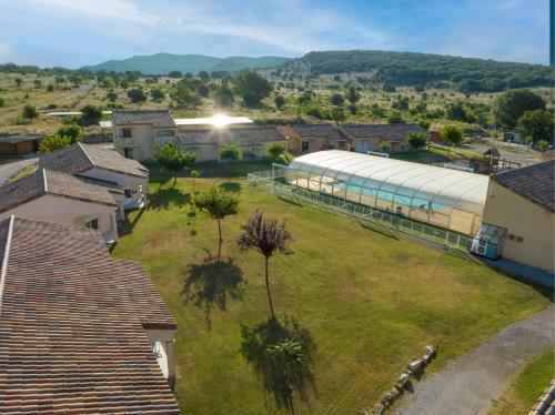 - une vue aérienne sur un grand bâtiment dans un village dans l'établissement Park & Suites Village Gorges de l'Hérault-Cévennes, à Brissac