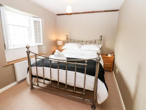 a bedroom with a metal bed in a room at Pheasant Cottage in Richmond