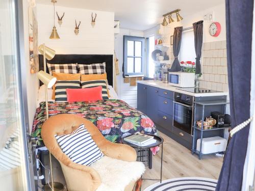 Creed Cabin في ستورنووي: غرفة نوم صغيرة بها سرير ومطبخ