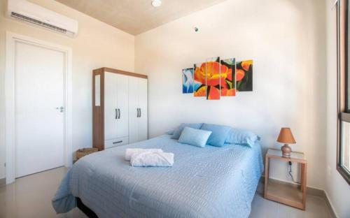 a bedroom with a blue bed and a painting on the wall at Delicado Monoambiente-comfy Studio in Luque