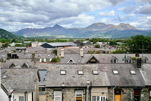 a group of roofs of houses with mountains in the background at Porthmadog, Sleeps 11, 5 Bedrooms, 5 Bathrooms, Mountain Views in Porthmadog