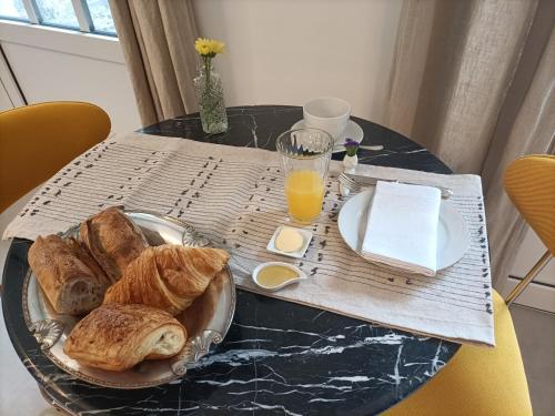 een tafel met croissants en jus d'orange bij Villa Buffon in Angers