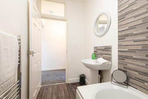 a bathroom with a tub and a sink and a mirror at Richardson Place in Kirk Merrington