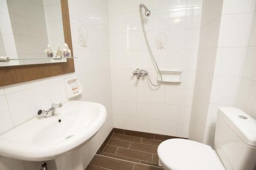 a white bathroom with a sink and a toilet at La Luna in Kala Nera