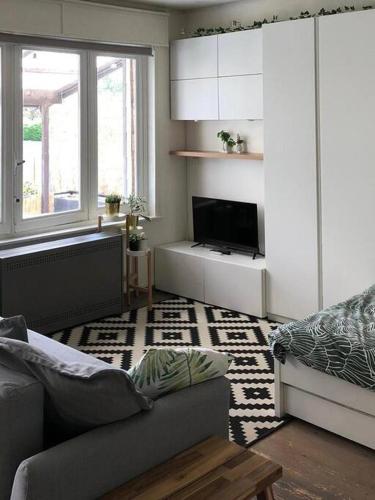 a living room with a couch and a tv at Studio Zeezucht in Blankenberge