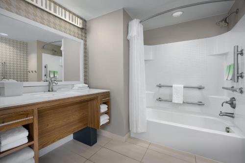 a bathroom with a white tub and a sink and a bath tubermott at Home2 Suites by Hilton Jacksonville, NC in Jacksonville