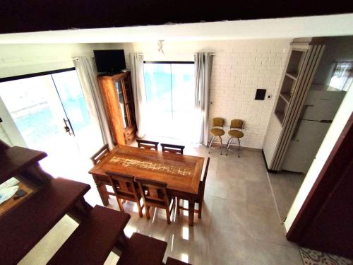 een woonkamer met een houten tafel en stoelen bij Morada Guarda Paradise in Guarda do Embaú