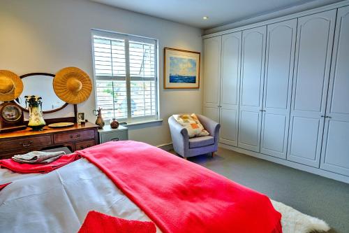 a bedroom with a bed and a mirror and a chair at Finest Retreats - Kings Wharf - Luxury Riverside Home in Burnham on Crouch