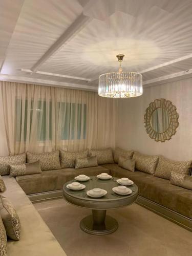 a living room with a couch and a table at Apartment Tanger Achakar with pool nearby sea in Tangier