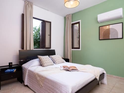 een slaapkamer met een bed met een boek erop bij Cute & Cozy Mazotos 1bed Getaway in Mazotos