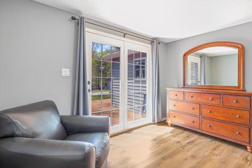 a living room with a chair and a dresser and a mirror at Eternal Sunrises in Sunrise Beach