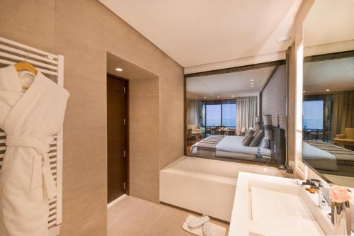een badkamer met een bad en een slaapkamer bij Widiane Resort in Bine el Ouidane