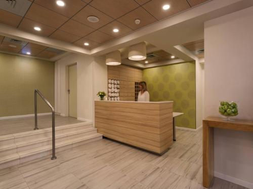 a woman standing at a counter in a lobby at Prima Kings Hotel in Jerusalem