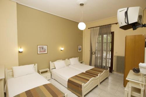 a hotel room with two beds and a tv at La Luna in Kala Nera