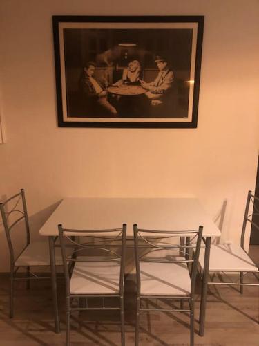 a table and chairs with a picture on the wall at Eine 2 Zimmer Ferienwohnung Münster City in Münster
