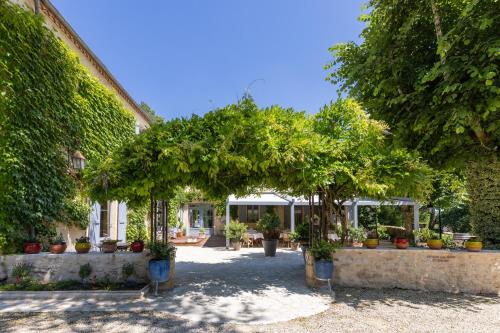 a garden with trees and potted plants at Le Moulin de Mitou in Auriac-du-Périgord