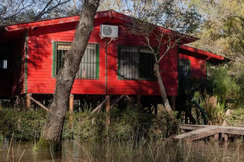 una casa roja con un aro de baloncesto delante en Casa isleña Extasis Propio en Tigre