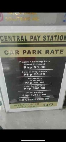 a sign that says central pay station car park rate at Air Residences Airbnb in Manila